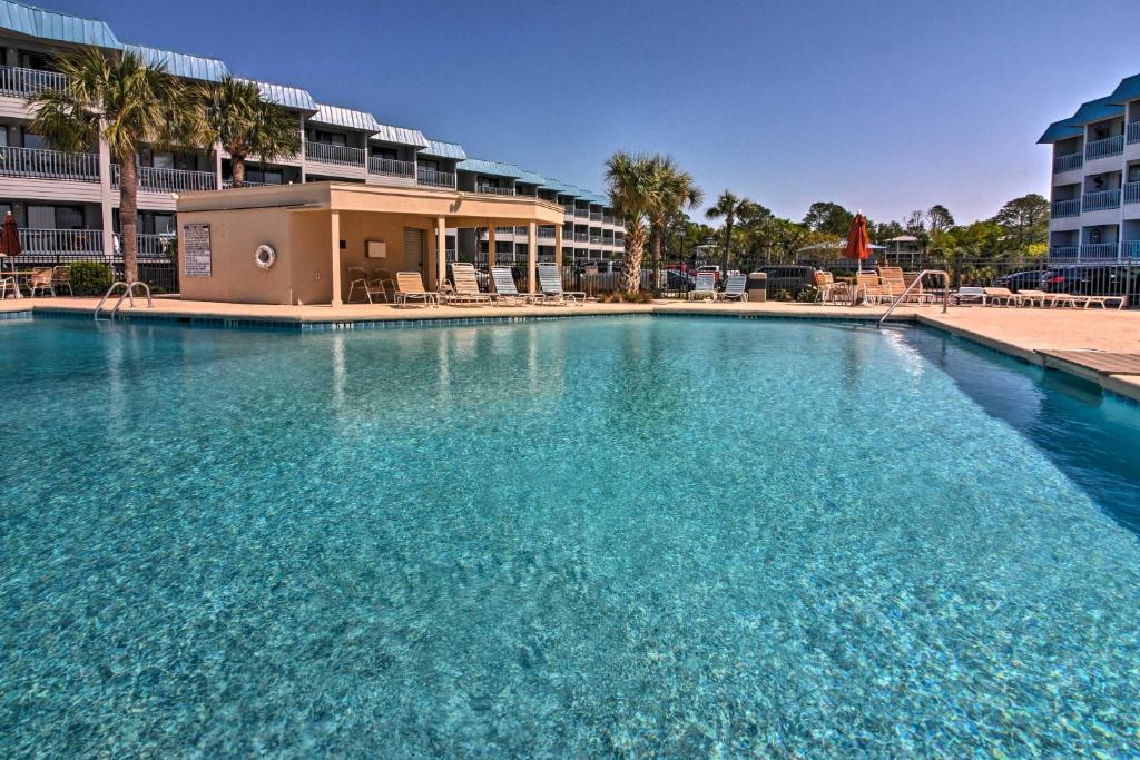 a large pool of blue water in front of a building at Breezy Tybee Island Condo - 100 Yards from Beach! in Tybee Island