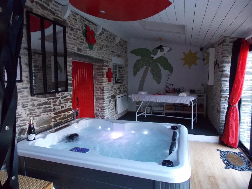 bañera grande en una habitación con dormitorio en DOL' IN LOVE Love room BDSM 4 étoiles en Dol-de-Bretagne