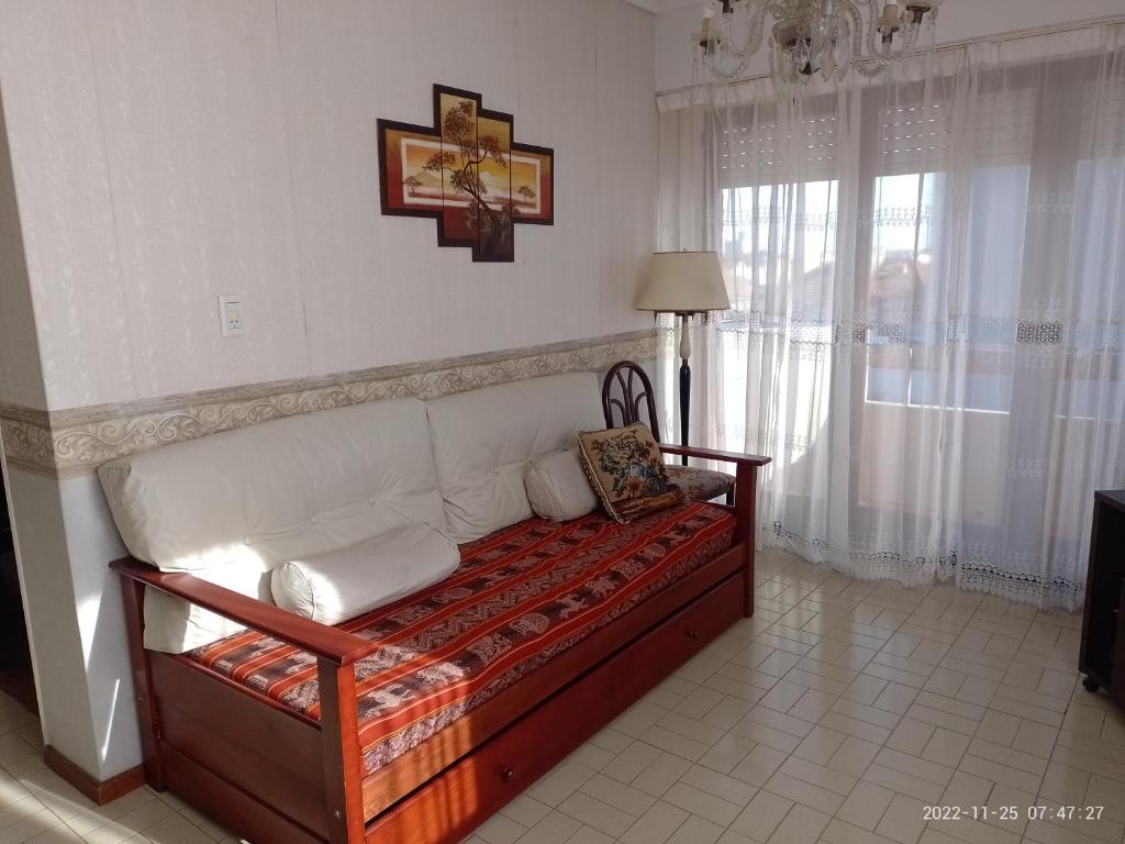 uma sala de estar com um sofá e uma janela em Departamento frente al Mar. em Mar del Plata