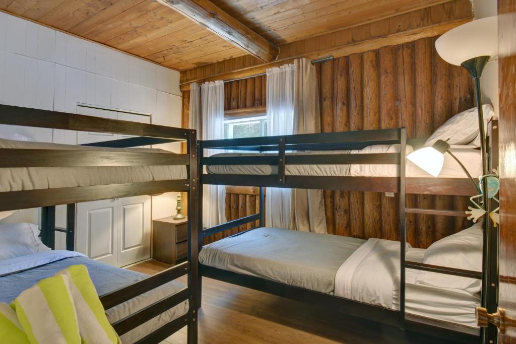 a bedroom with two bunk beds in a cabin at Nelson Warm Log Cabin with Private Hot Tub in Rivière-Rouge