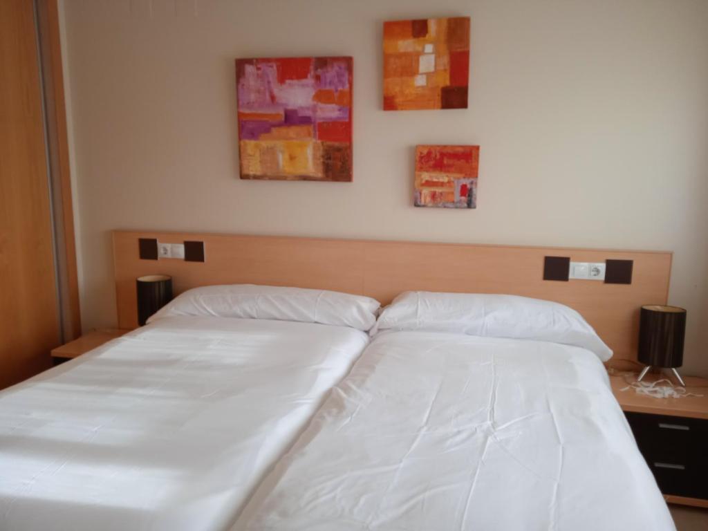 a bed with two white pillows on top of it at Residencial Los Flamencos in Benicàssim