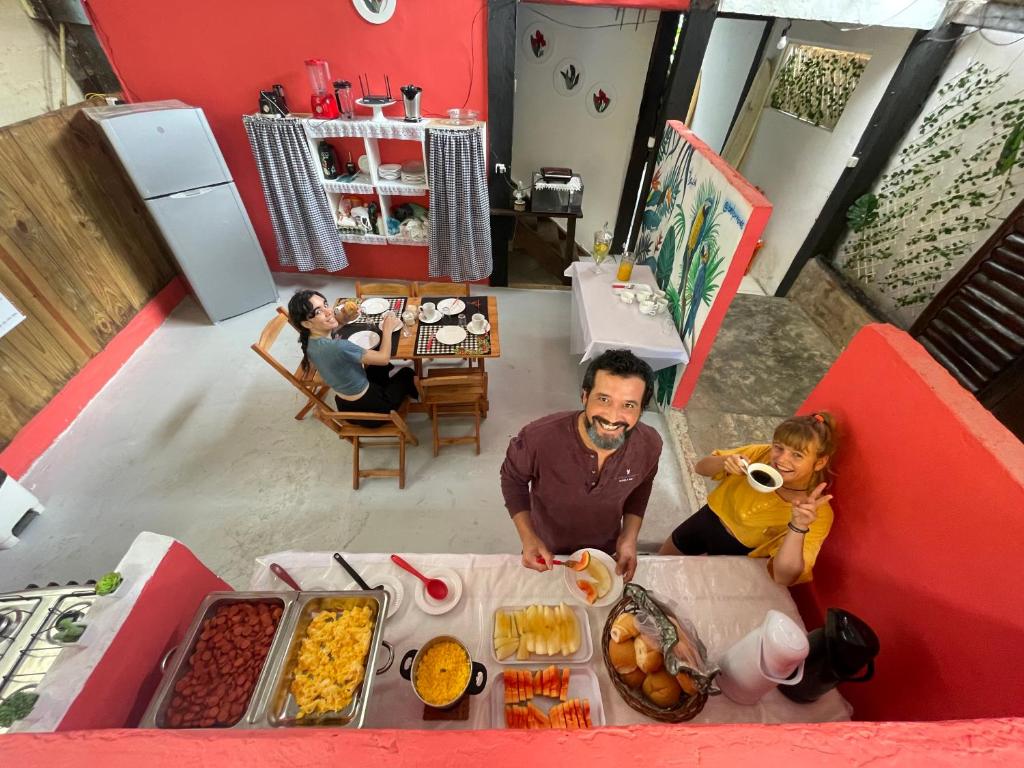 a man and a woman sitting at a table with food at Ooxe Hostel in Itacaré