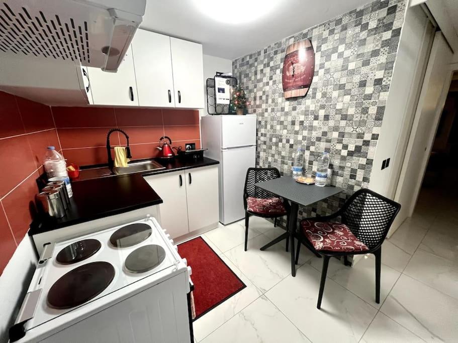 Il comprend une cuisine équipée d'une cuisinière et d'une table avec des chaises. dans l'établissement Cute Penthouse, à Marsaskala