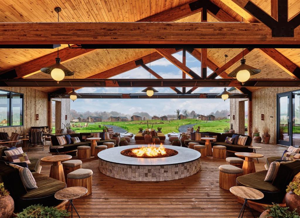 een lobby met een vuurplaats en stoelen en tafels bij Wildflower Farms, Auberge Resorts Collection in Gardiner