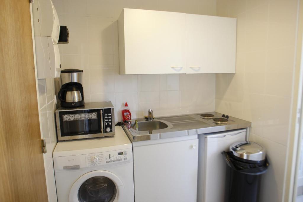 a small kitchen with a washing machine and a sink at RENT APPART - Colombes in Colombes