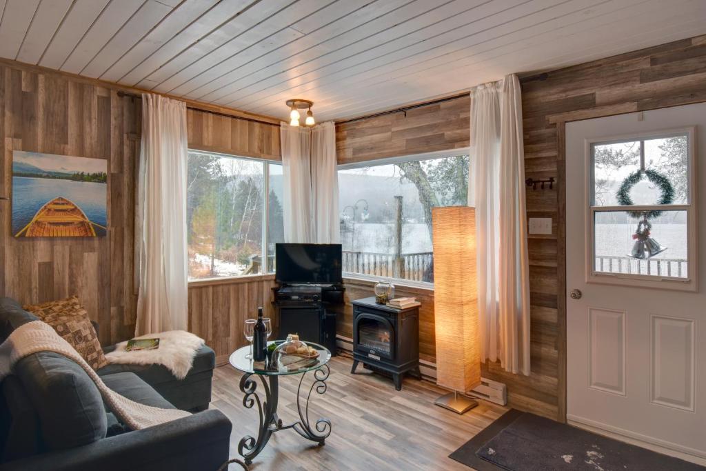 a living room with wood paneling and a fireplace at Alison A Romantic Getaway With Private Hot Tub in Rivière-Rouge