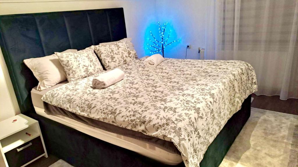 1 dormitorio con 1 cama grande con luz azul en Apartment Studenac en Pale