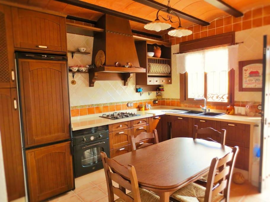 cocina con mesa de madera, mesa y sillas en Casa Juan Gil, en Almería