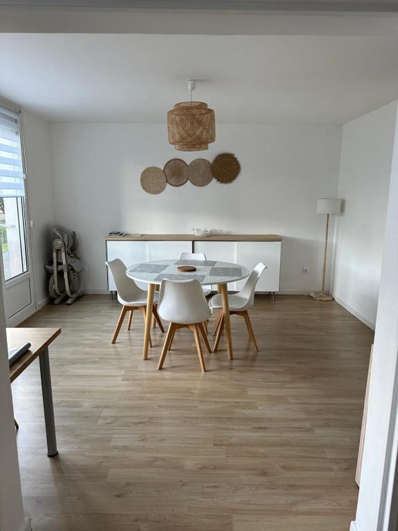 een eetkamer met een tafel en stoelen bij Appartement Dunkerque proximité plage et centre ville in Duinkerke