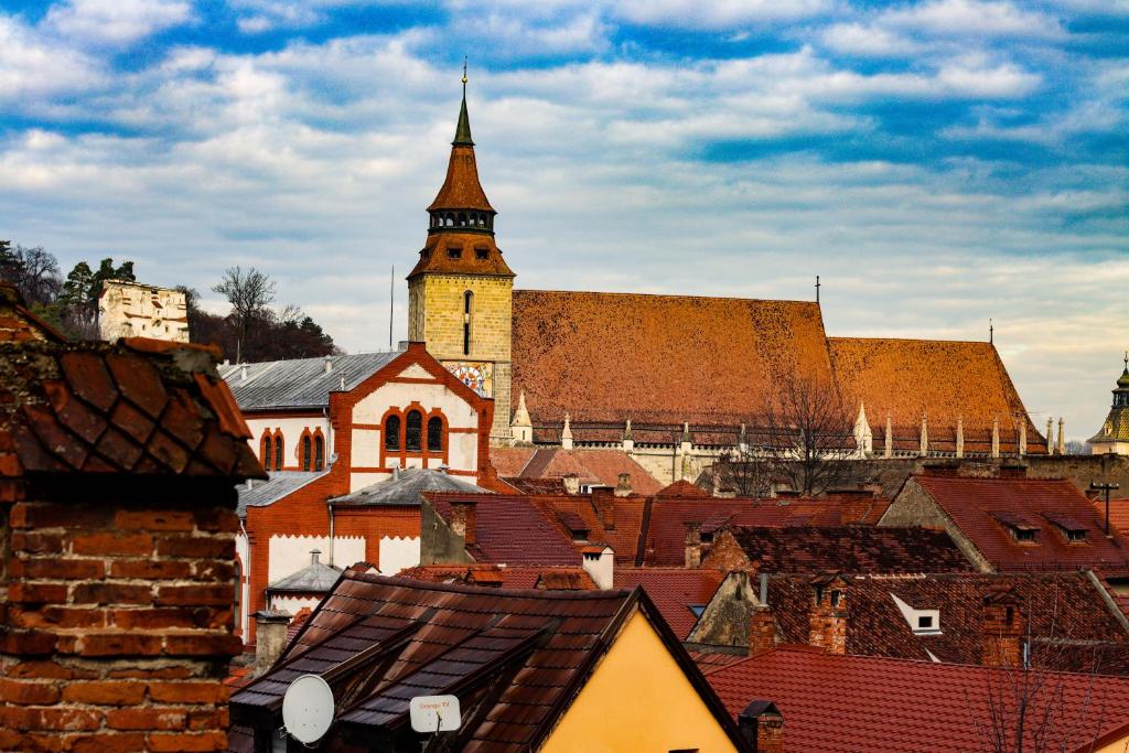 a view of a city with a church and roofs at Charm Old Town Studio in Braşov