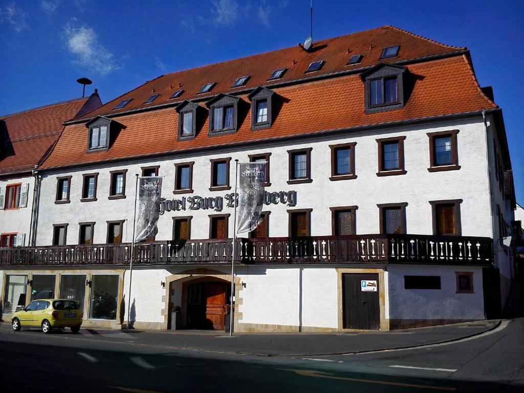 ein großes weißes Gebäude mit rotem Dach in der Unterkunft Hotel Burg Breuberg in Höchst im Odenwald