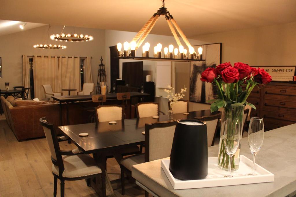 a dining room with a table with red roses in a vase at Midtown/Downtown-Luxury2BR+Patio-Heart of City in Houston