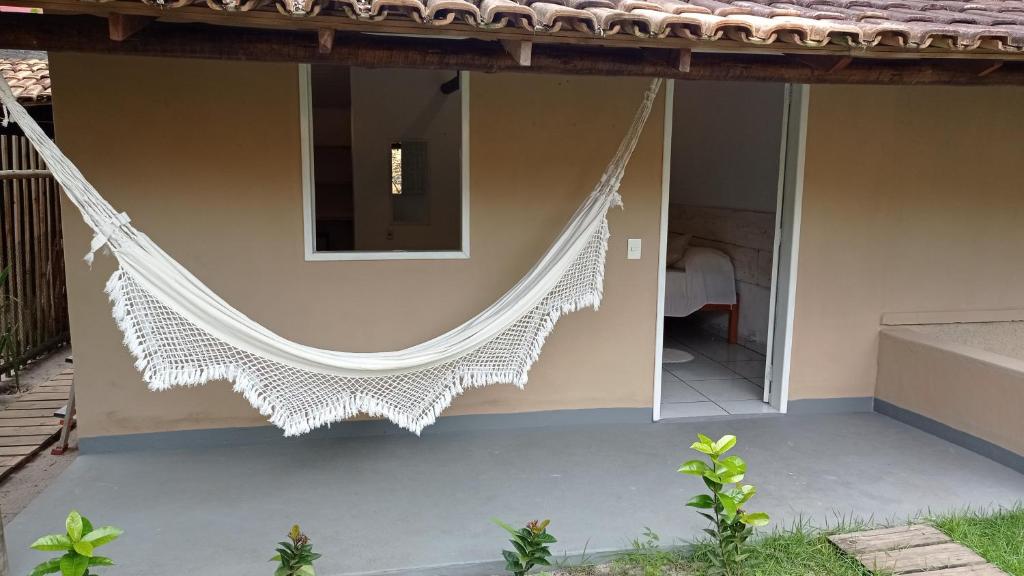 a balcony of a house with a hammock on it at Pousada Amora Caraiva in Caraíva