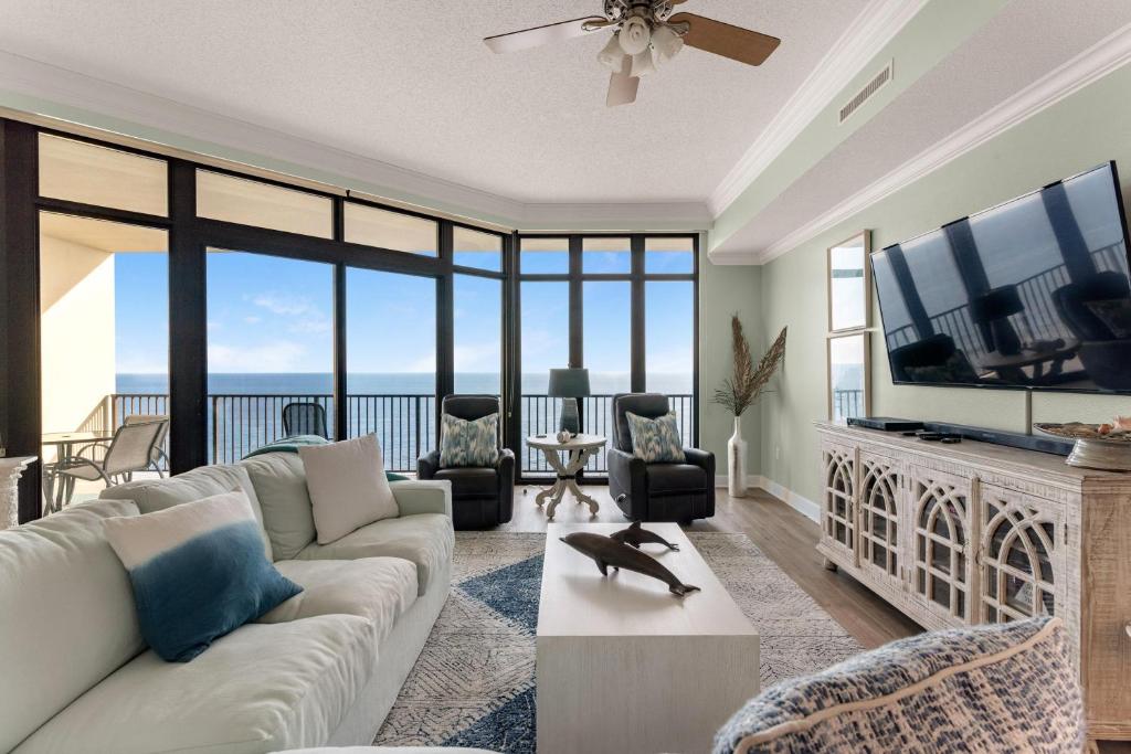 a living room with a couch and a flat screen tv at Phoenix West 1508 in Orange Beach