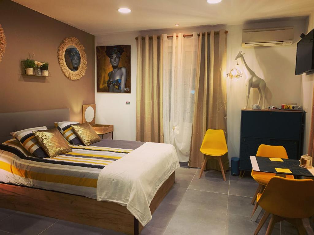LA DI MARIA في ناربون: غرفة نوم بسرير وطاولة وكراسي