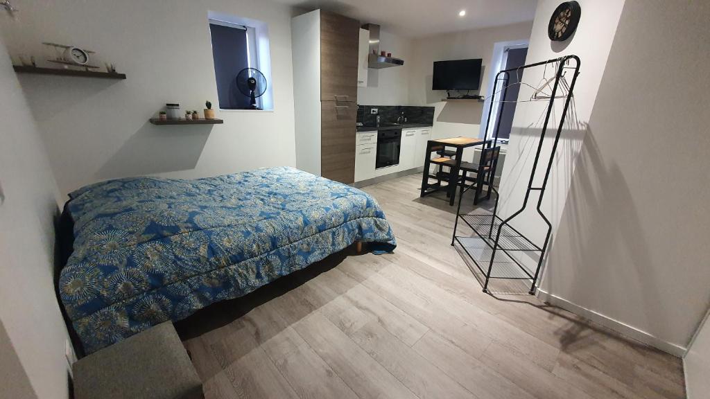 ein kleines Schlafzimmer mit einem Bett und einer Küche in der Unterkunft Studio in Baccarat