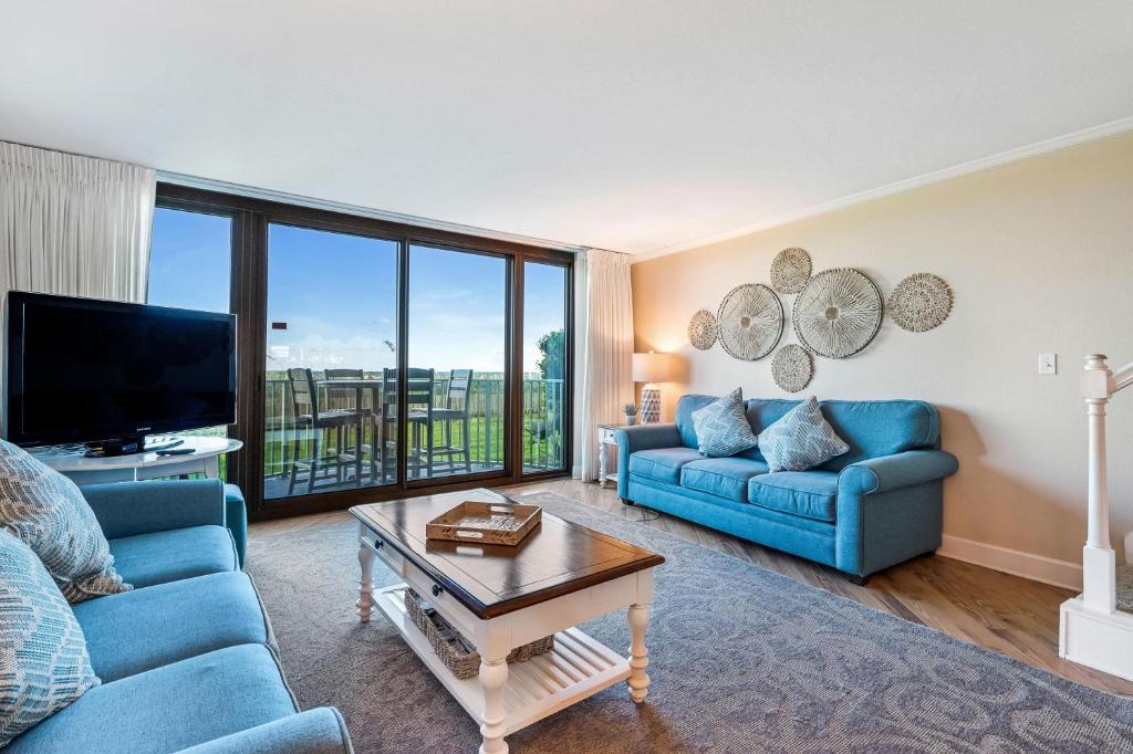 a living room with two blue couches and a tv at Perdido Towers East 104 in Perdido Key