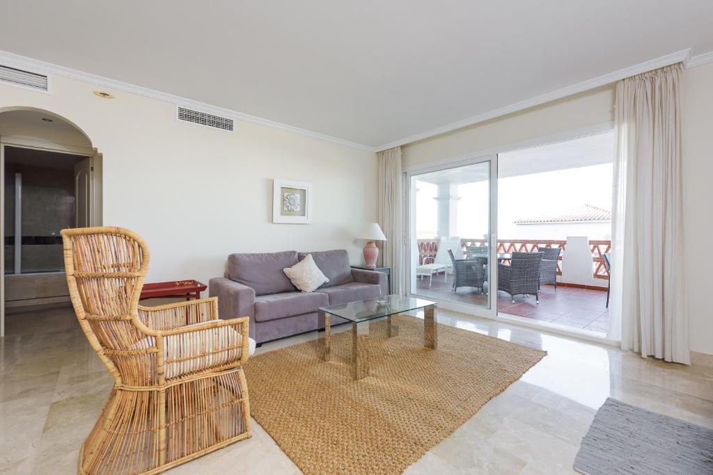 ein Wohnzimmer mit einem Sofa und einem Glastisch in der Unterkunft Stay U-nique Apartments Orbaneja in Mijas
