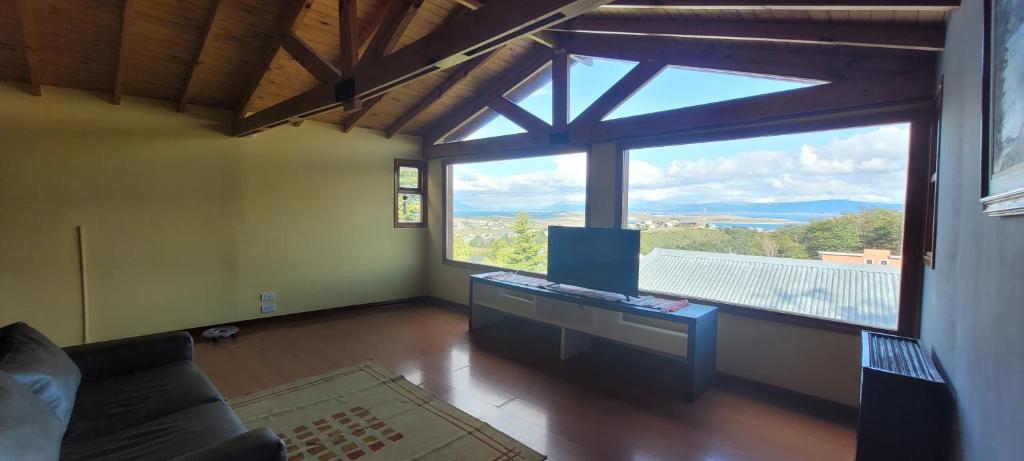 sala de estar con ventana grande y sofá en Pabloush en Ushuaia