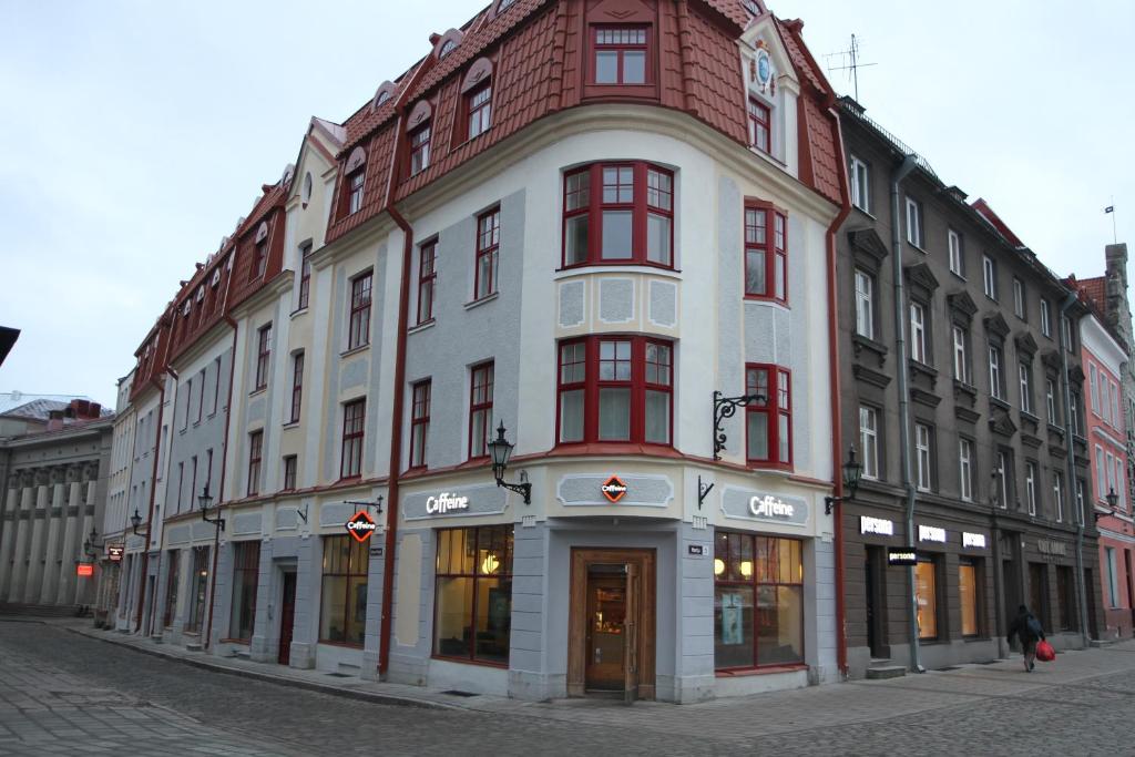 un gran edificio con ventanas rojas en una calle en Harju Old Town Apartment en Tallin