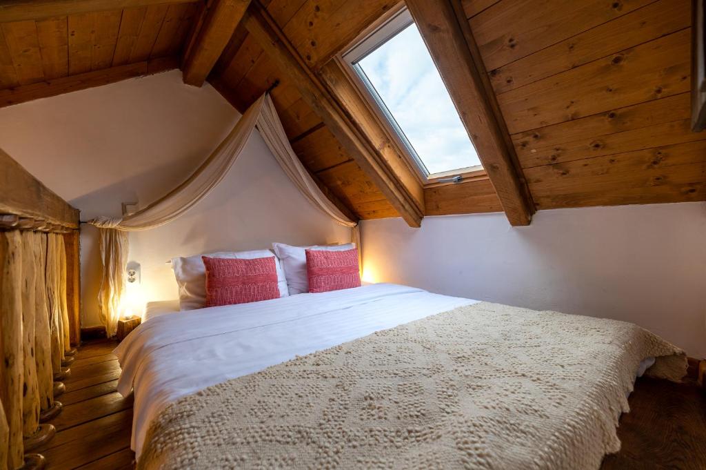 a bedroom with a large bed with red pillows at Boutique Hotel von Graf in Sighişoara