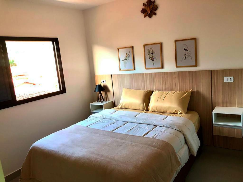 Un dormitorio con una cama grande y una ventana en Apto c otima localizacao e WiFi Pocos de Caldas MG, en Poços de Caldas