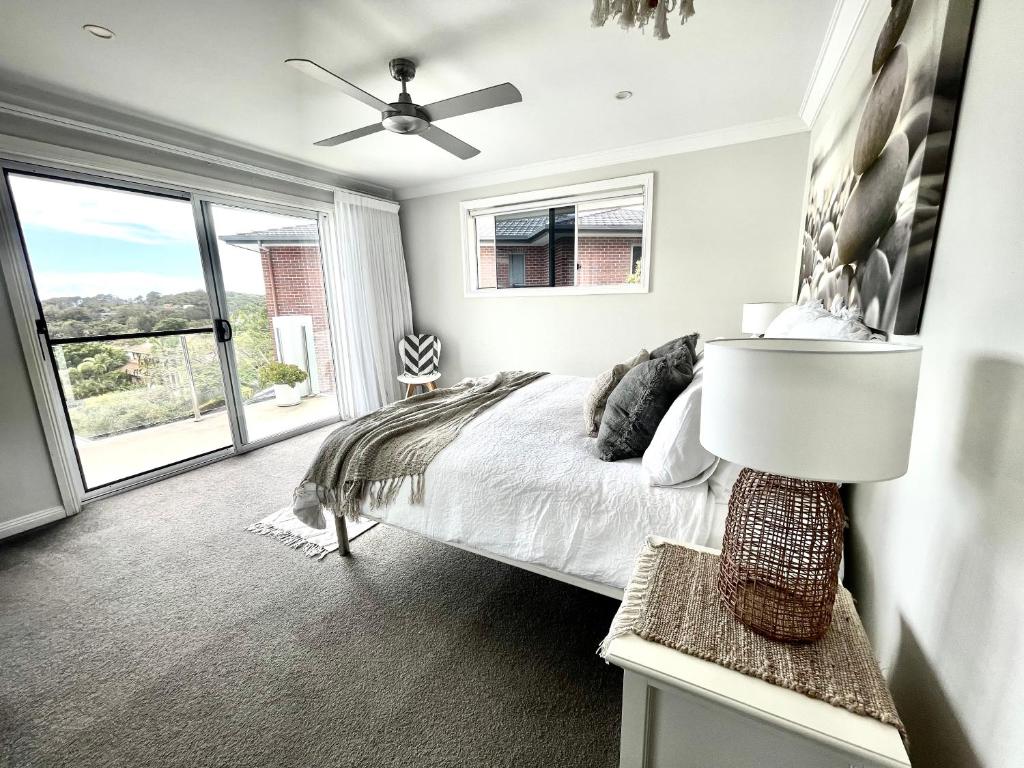 a bedroom with a bed and a ceiling fan at Diggers Beach Villa Coffs Harbour in Coffs Harbour