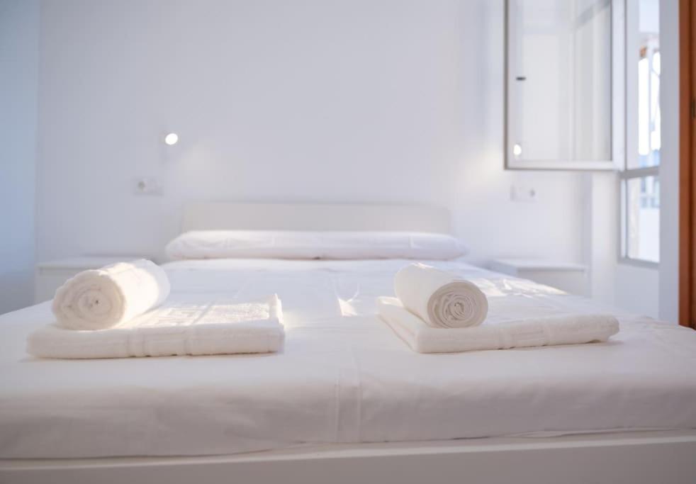 białe łóżko z dwoma białymi ręcznikami w obiekcie Apartamento Jogi Playa del inglés w mieście San Bartolomé