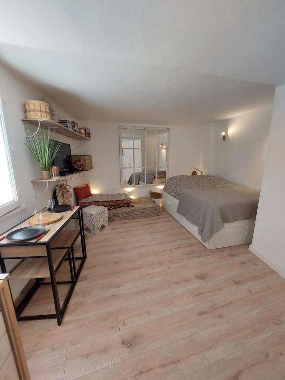 une chambre avec un lit et un bureau dans une pièce dans l'établissement Hyères studio refait à neuf dans la cité médiévale, à Hyères