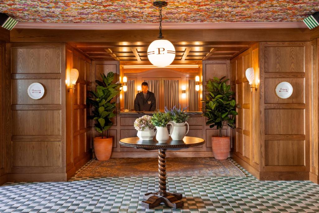 a man standing in front of a mirror in a room at Palihouse West Hollywood in Los Angeles