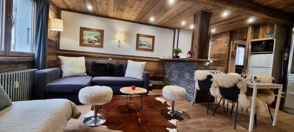 ein Wohnzimmer mit einem Sofa, einem Tisch und Stühlen in der Unterkunft Logement à Megève avec Jardin in Megève