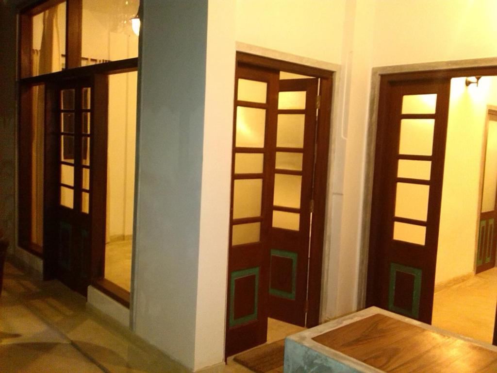 a room with three doors and a wooden floor at Silva Rest in Unawatuna