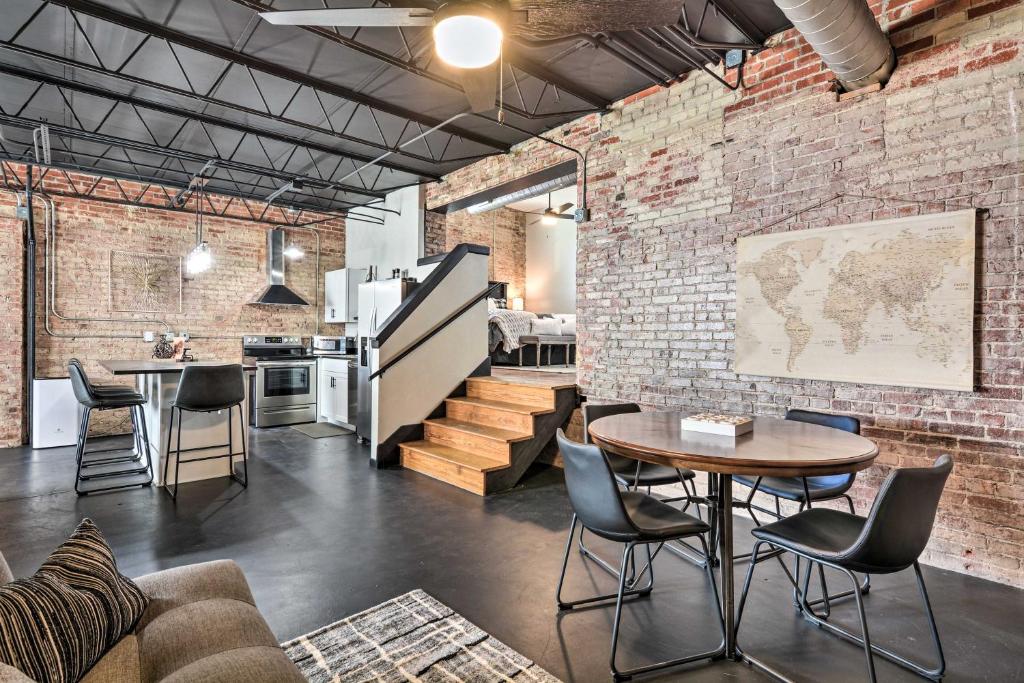 an industrial loft with brick walls and a table and chairs at Sleek, Modern Loft in Downtown Springfield! in Springfield