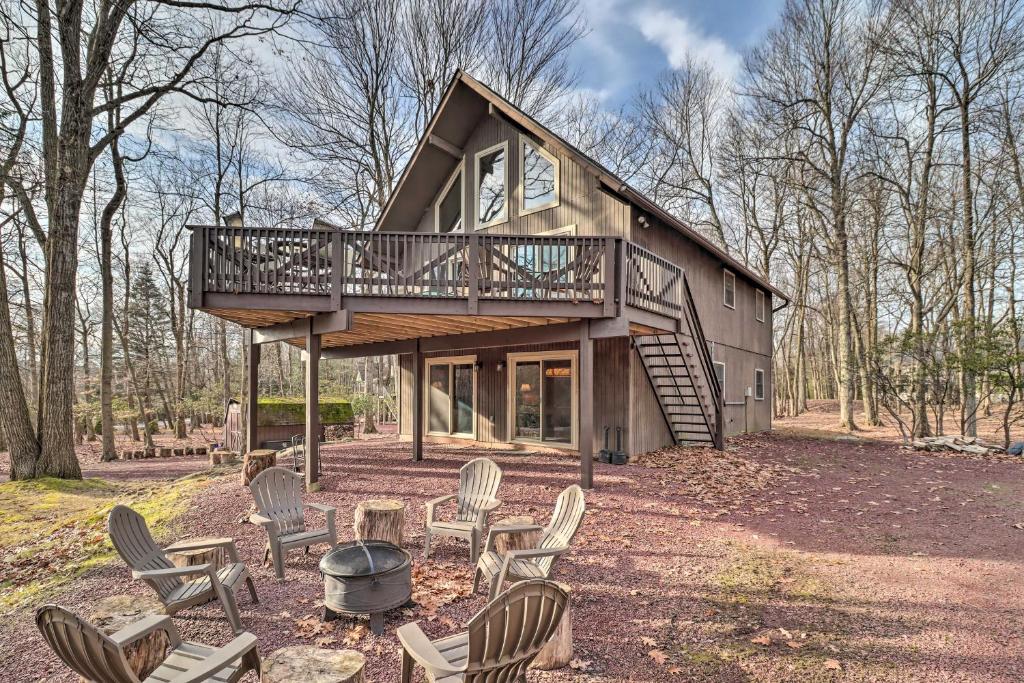 a cabin in the woods with a deck and chairs at Lake Harmony Home with Game Room and Fire Pit! in Lake Harmony