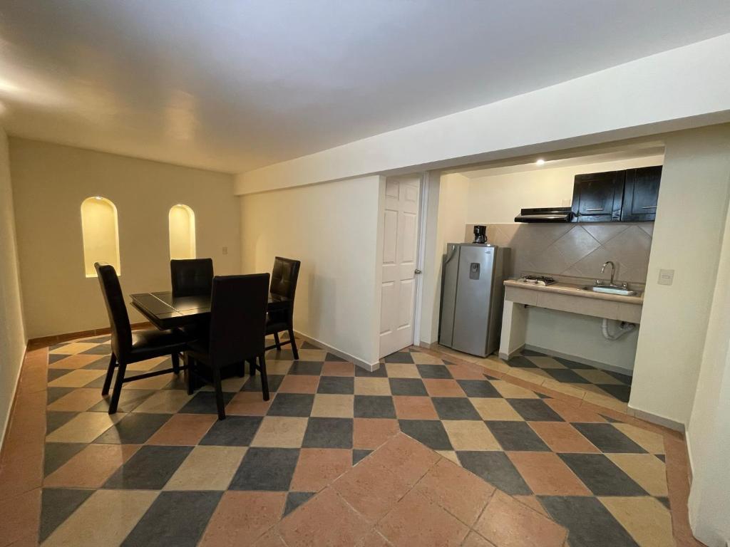 a living room with a table and chairs and a kitchen at Hotel Real Home in Tula de Allende