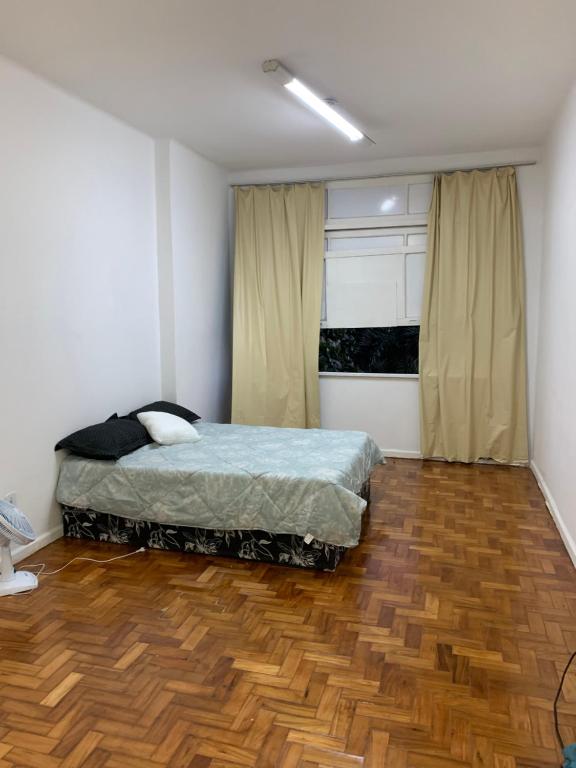 Apê Minimalista Melhor do Centro Self check-in في ريو دي جانيرو: غرفة نوم بسرير وارضية خشبية