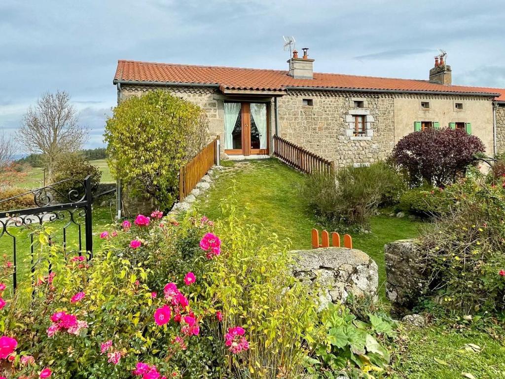 a stone house with a garden and flowers at Gîte Saugues, 4 pièces, 6 personnes - FR-1-582-127 in Saugues