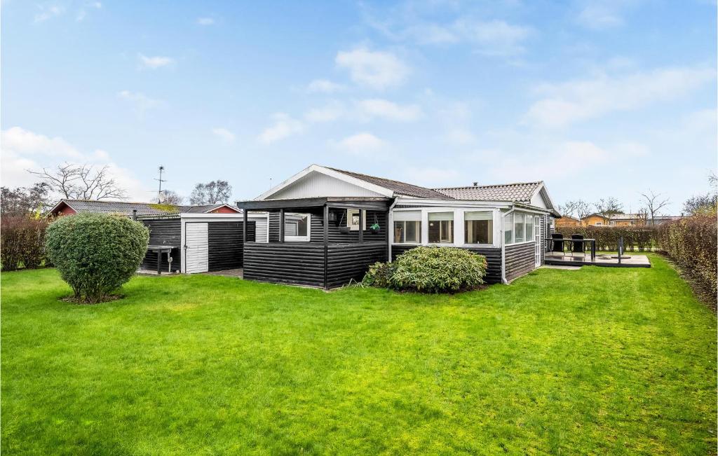 a house with a green yard in front of it at 3 Bedroom Gorgeous Home In Haderslev in Haderslev