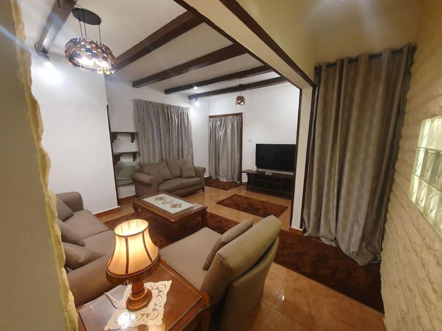 - un salon avec un canapé et une table dans l'établissement Cozzy home with private entrance, au Caire
