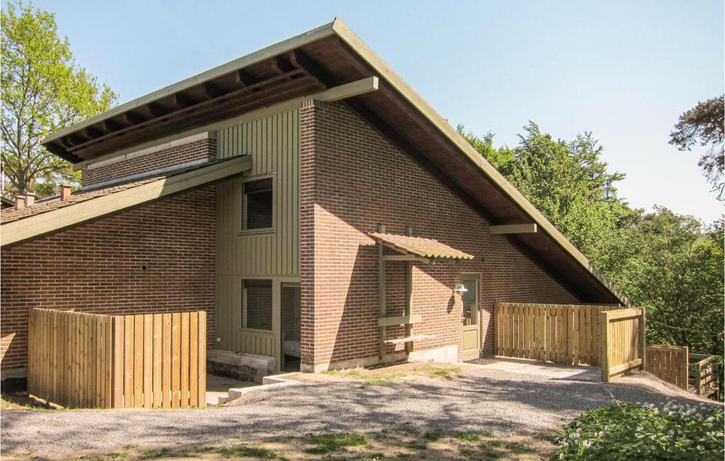 a brick house with a wooden fence in front of it at 2 Bedroom Stunning Apartment In Allinge in Allinge