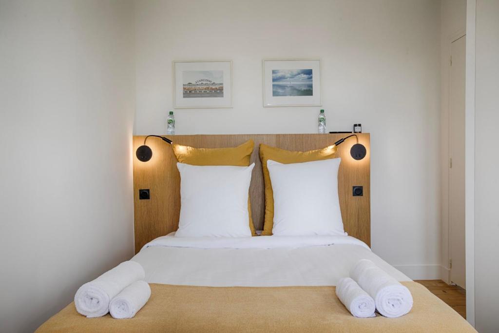sypialnia z łóżkiem z białą pościelą i poduszkami w obiekcie La Villa Suzanne - Two Bedrooms - Deauville Beach w mieście Deauville