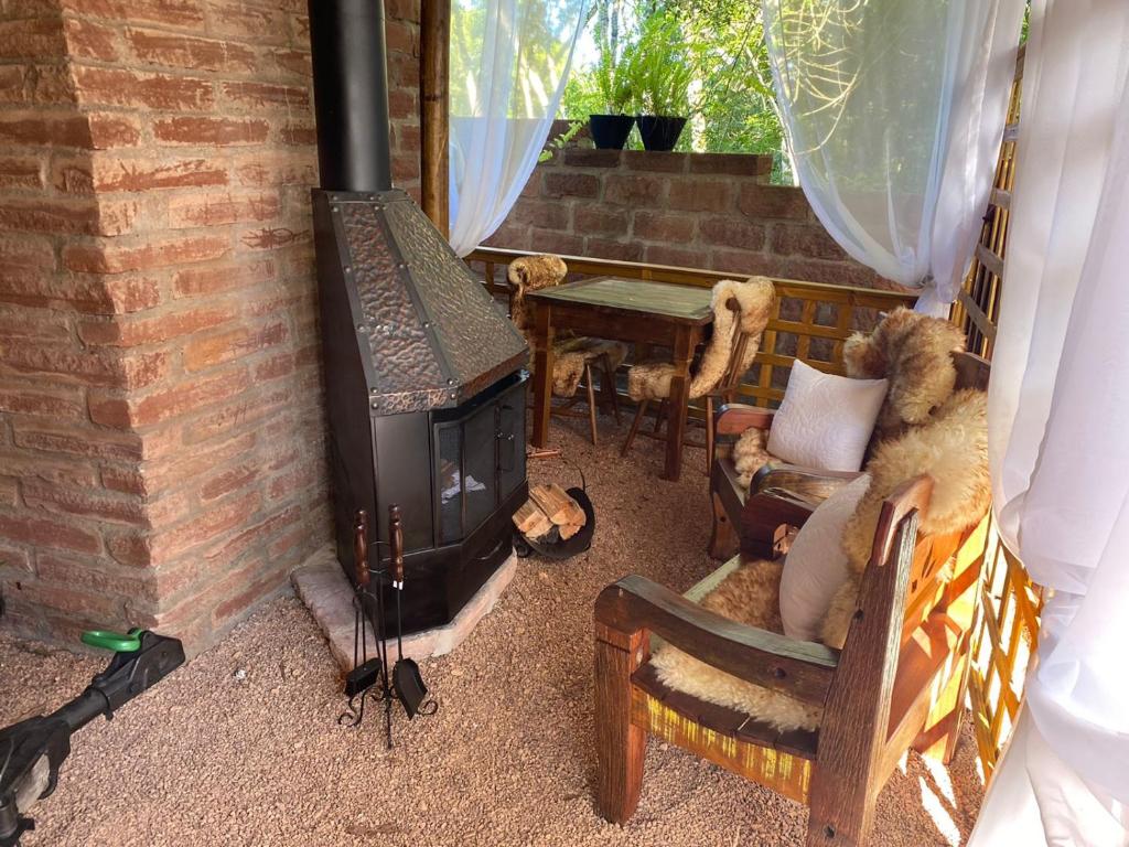 a living room with a wood stove and a table at Chale Sobre Rodas e Spa Exclusive - Localizado Próximo do Centro in Canela