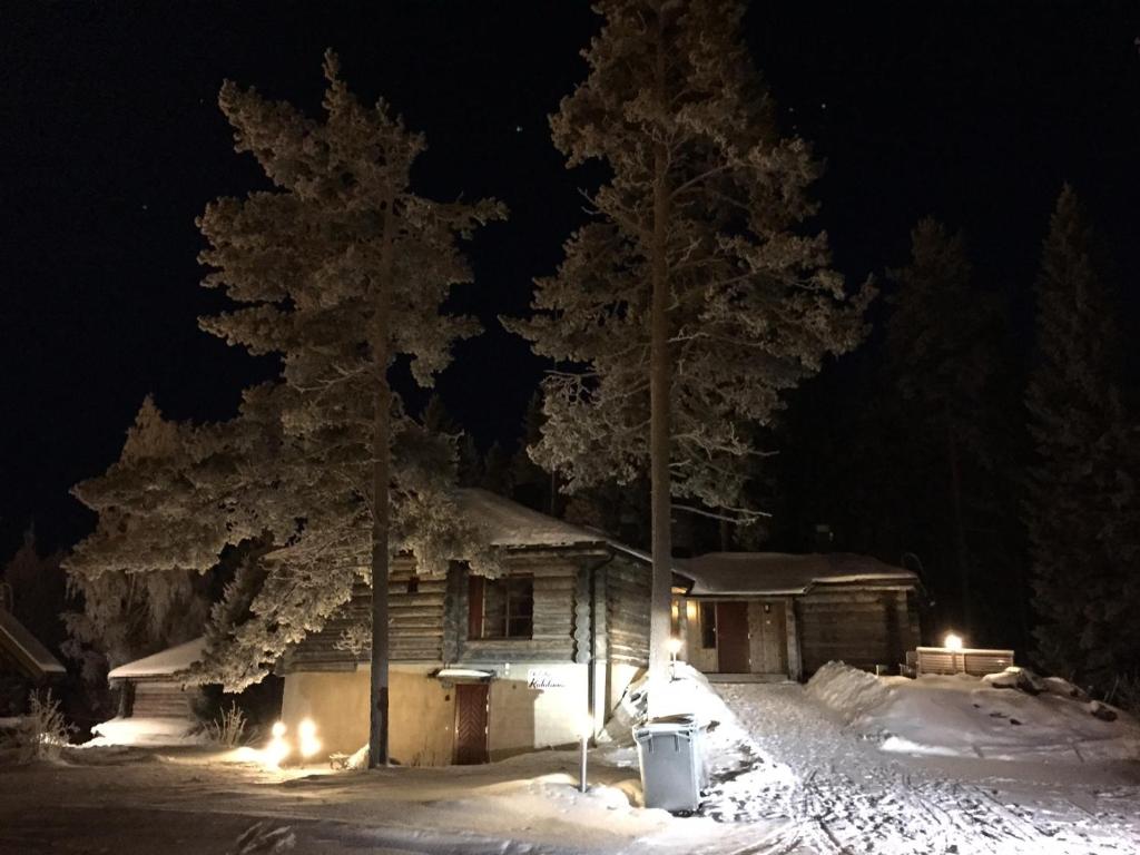 a cabin with lights in the snow at night at Riihilinna Ski Lodge in Muurame