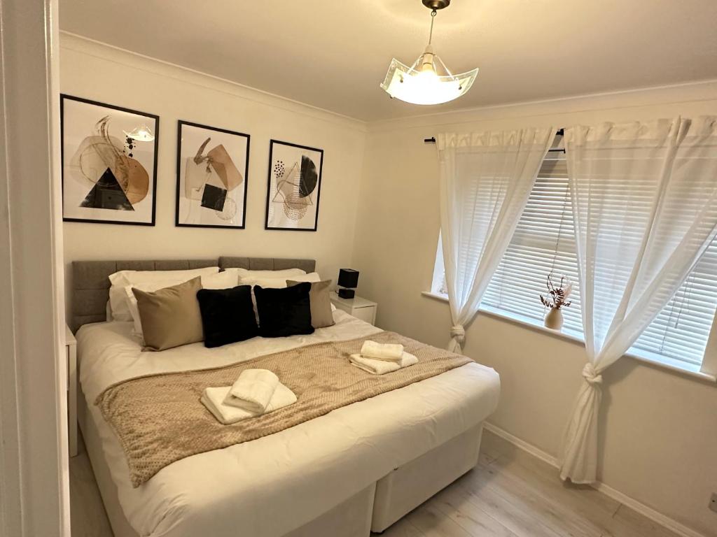 - une chambre avec un grand lit et 2 serviettes dans l'établissement Stylish 1 Bedroom close to Tooting Bec Station, à Londres