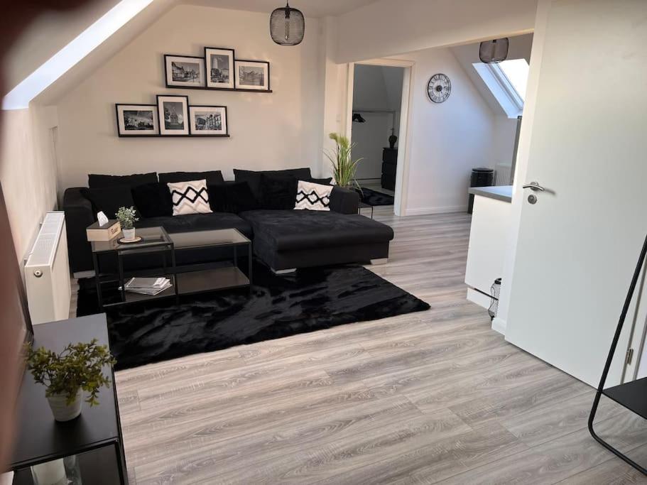 a living room with a black couch and a table at 5Minuten von der City entfernte Wohnung mit Parkpl in Bielefeld