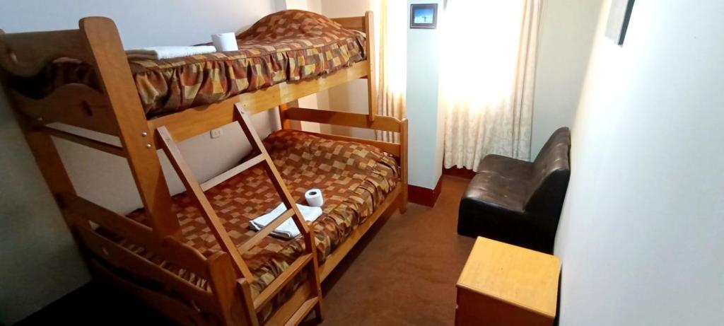 Cette petite chambre comprend 2 lits superposés et une chaise. dans l'établissement Andes Hostel, à Huaraz