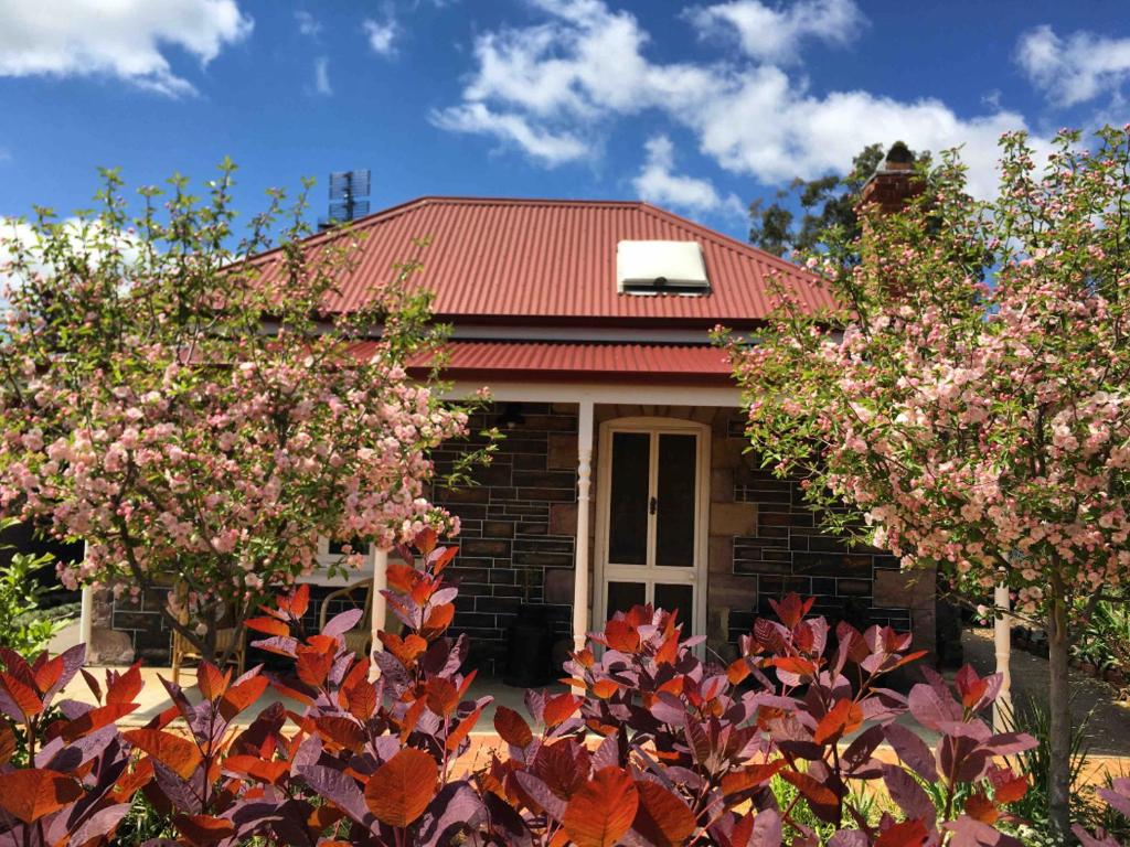 una casa con techo rojo y algunos árboles en Randell Cottage - Adelaide Hills - Cosy Rustic Hideaway, en Gumeracha
