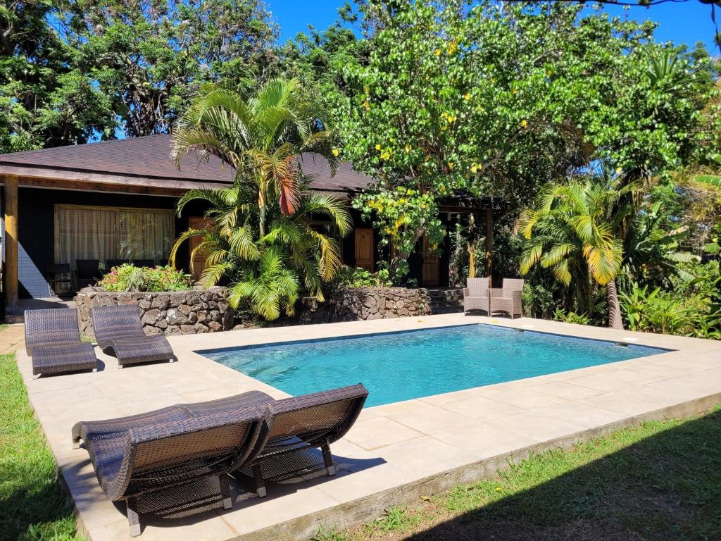 una piscina con sillas y una casa en Te Ariki - Adults Only en Hanga Roa