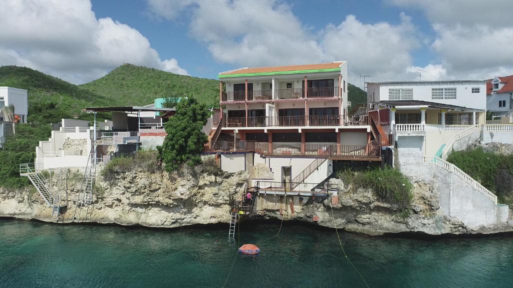 威廉斯塔德的住宿－Lagun Ocean View Villa with Own Private Beach，水边悬崖上的建筑物