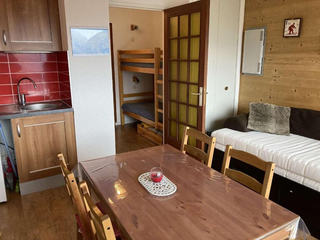 eine Küche und ein Esszimmer mit einem Tisch und einem Bett in der Unterkunft Appartement Auris, 1 pièce, 3 personnes - FR-1-297-326 in Auris